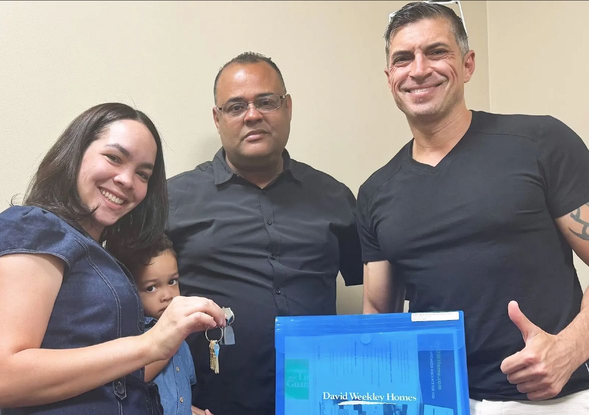A family holding keys at their David Weekley Homes closing