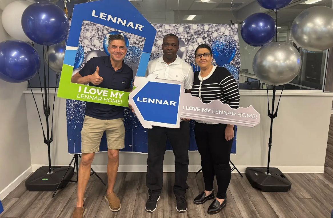 Robert with a couple holding a Lennar closing frame and key