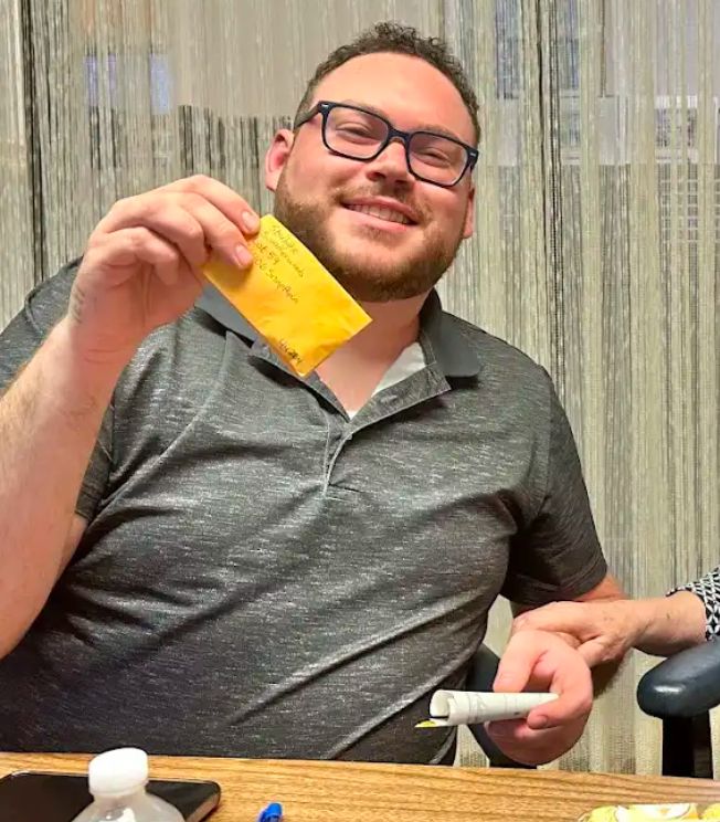 A happy buyer holding up the envelope with his new keys