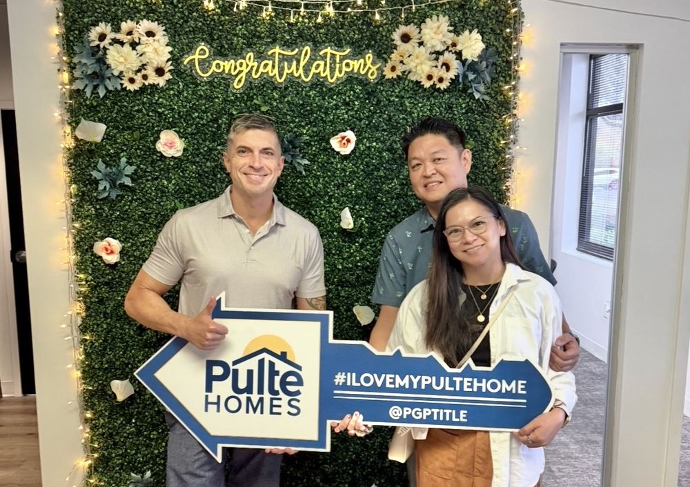 Robert with a couple holding a Pulte Homes key sign